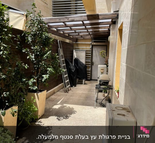חצר עם עציצים, סולם ומנגל מכוסה